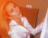 Майли Сайрус позирует в сверкающем комбинезоне и ботфортах